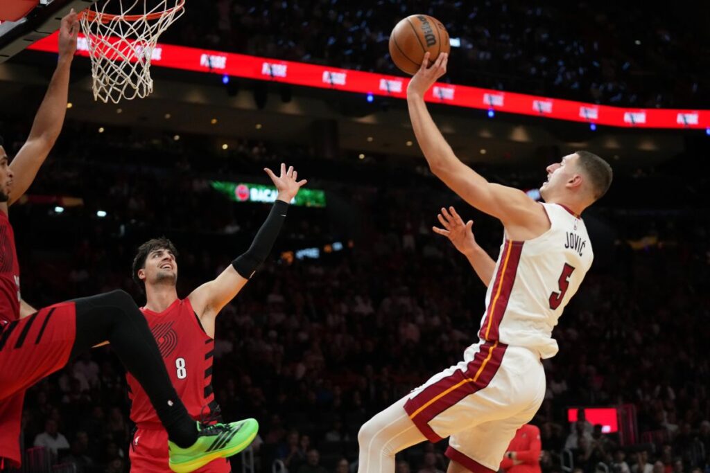 Miami Heat forward Nikola Jovic (5) shoots as Portland Trail Blazers forward Deni Avdija (8) defends during the second half of an NBA basketball game, Saturday, Nov. 8, 2025, in Miami. (AP Photo/Lynne Sladky)