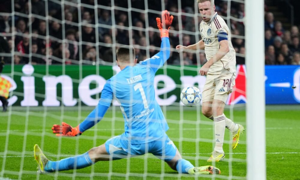 Benfica's goalkeeper Anatoliy Trubin makes a save in front of Ajax's Davy Klaassen during the Champions League opening phase soccer match between Ajax and SL Benfica in Amsterdam, Netherlands, Tuesday, Nov. 25, 2025. (AP Photo/Peter Dejong)