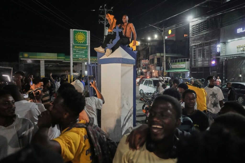 Fans celebrate Haiti's qualification for the 2026 FIFA World Cup after a soccer match against Nicaragua, in Port-au-Prince, Haiti, Tuesday, Nov. 18, 2025. (AP Photo/Odelyn Joseph)