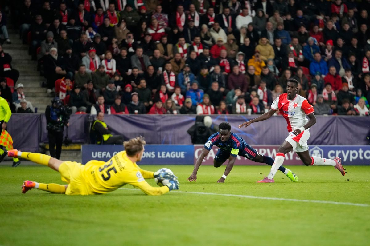 Slavia's goalkeeper Jakub Markovic, left, makes a save in front of Arsenal's Bukayo Saka, center, as Slavia's Youssoupha Mbodjiduring looks on the Champions League opening phase soccer match between Slavia Prague and Arsenal in Prague, Czech Republic, Tuesday, Nov. 4, 2025. (AP Photo/Petr David Josek)
