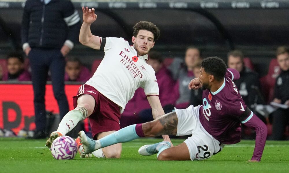 Arsenal's Declan Rice, left, challenges for the ball with Burnley's Josh Laurent during the English Premier League soccer match between Burnley and Arsenal in Burnley, England, Saturday, Nov. 1, 2025. (AP Photo/Jon Super)