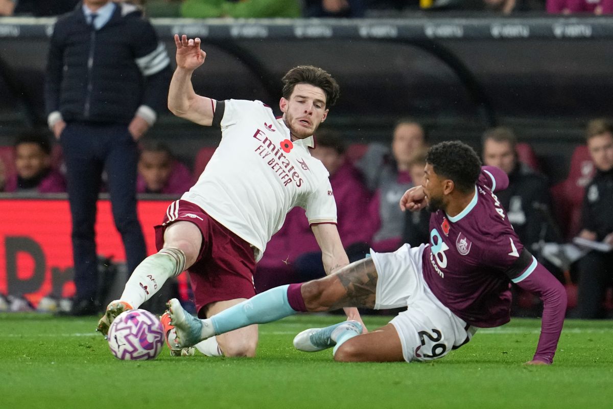 Arsenal's Declan Rice, left, challenges for the ball with Burnley's Josh Laurent during the English Premier League soccer match between Burnley and Arsenal in Burnley, England, Saturday, Nov. 1, 2025. (AP Photo/Jon Super)