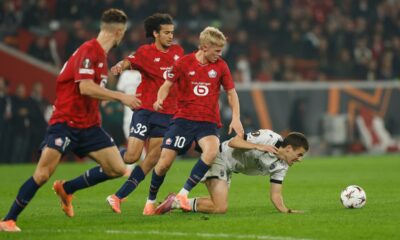PAOK's Giannis Konstantelias, right, challenges for the ball with Lille's Ayyoub Bouaddi, second from left, and Hakon Arnar Haraldsson, second from right, during the Europa League opening phase soccer match between Lille and PAOK in Villeneuve-d'Ascq, outside Lille, France, Thursday, Oct. 23, 2025. (AP Photo/Jean-Francois Badias)