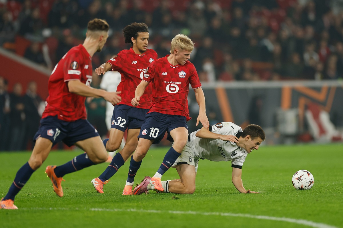 PAOK's Giannis Konstantelias, right, challenges for the ball with Lille's Ayyoub Bouaddi, second from left, and Hakon Arnar Haraldsson, second from right, during the Europa League opening phase soccer match between Lille and PAOK in Villeneuve-d'Ascq, outside Lille, France, Thursday, Oct. 23, 2025. (AP Photo/Jean-Francois Badias)