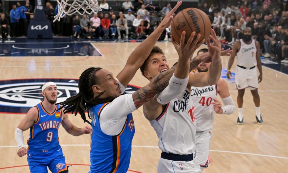 Los Angeles Clippers guard Bogdan Bogdanovic (10) drives Oklahoma City Thunder forward Jaylin Williams for a basket during the second half of an NBA basketball game Tuesday, Nov. 4, 2025, in Los Angeles. (AP Photo/Jayne Kamin-Oncea)