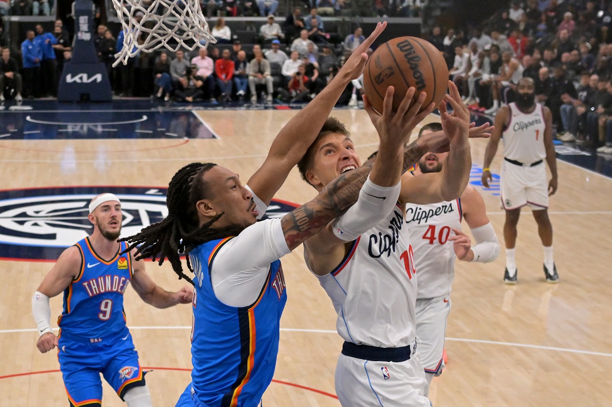 Los Angeles Clippers guard Bogdan Bogdanovic (10) drives Oklahoma City Thunder forward Jaylin Williams for a basket during the second half of an NBA basketball game Tuesday, Nov. 4, 2025, in Los Angeles. (AP Photo/Jayne Kamin-Oncea)