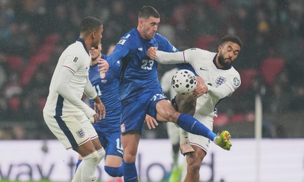 Serbia's Dusan Vlahovic, left, and England's Ezri Konsa fight for the ball during a World Cup qualifier group K soccer match between Serbia and England in London, Thursday, Nov. 13, 2025. (AP Photo/Kirsty Wigglesworth)