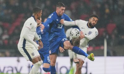 Serbia's Dusan Vlahovic, left, and England's Ezri Konsa fight for the ball during a World Cup qualifier group K soccer match between Serbia and England in London, Thursday, Nov. 13, 2025. (AP Photo/Kirsty Wigglesworth)