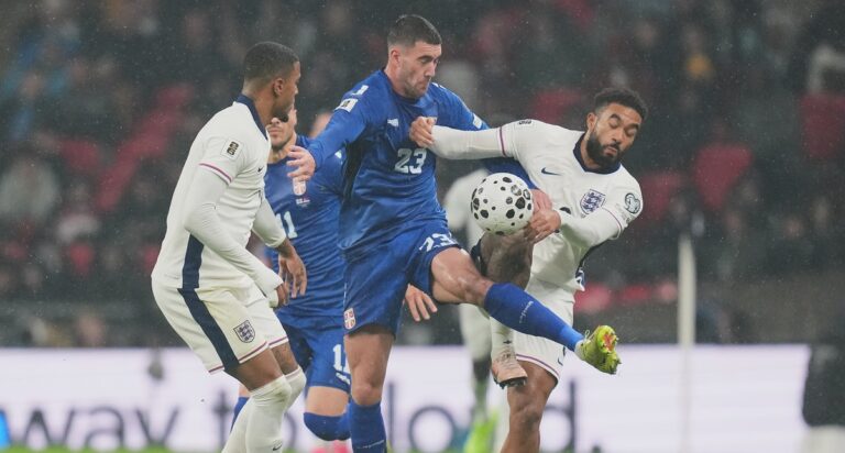 Serbia's Dusan Vlahovic, left, and England's Ezri Konsa fight for the ball during a World Cup qualifier group K soccer match between Serbia and England in London, Thursday, Nov. 13, 2025. (AP Photo/Kirsty Wigglesworth)