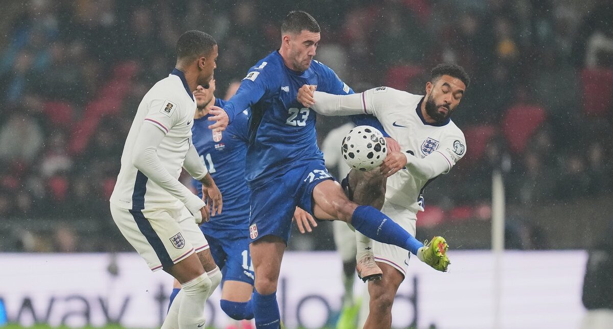 Serbia's Dusan Vlahovic, left, and England's Ezri Konsa fight for the ball during a World Cup qualifier group K soccer match between Serbia and England in London, Thursday, Nov. 13, 2025. (AP Photo/Kirsty Wigglesworth)