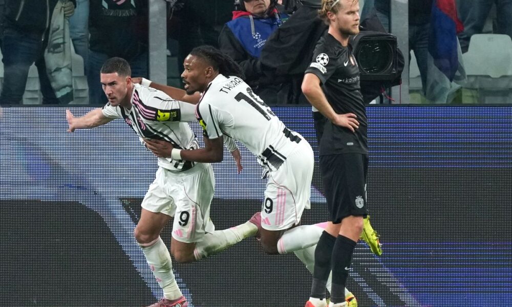 Juventus' Dusan Vlahovic, left, celebrates after scoring his side's first goal during the Champions League opening phase soccer match between Juventus and Sporting CP in Turin, Italy, Tuesday, Nov. 4, 2025. (AP Photo/Antonio Calanni)