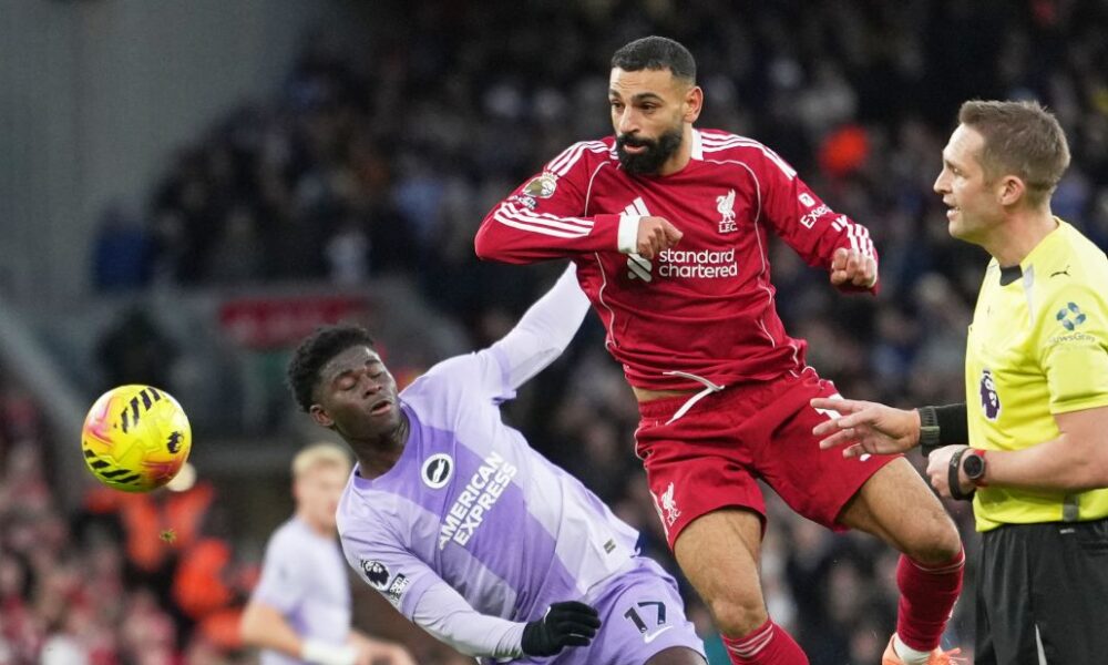 Liverpool's Mohamed Salah, centre, challenges for the ball with Brighton's Carlos Baleba, left, during the English Premier League soccer match between Liverpool and Brighton and Hove Albion in Liverpool, England, Saturday, Dec. 13, 2025. (AP Photo/Jon Super)