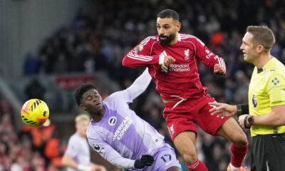 Liverpool's Mohamed Salah, centre, challenges for the ball with Brighton's Carlos Baleba, left, during the English Premier League soccer match between Liverpool and Brighton and Hove Albion in Liverpool, England, Saturday, Dec. 13, 2025. (AP Photo/Jon Super)