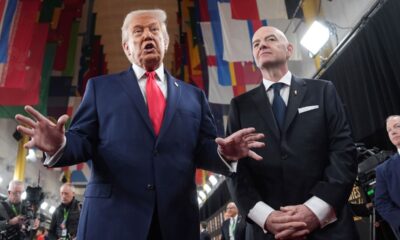 President Donald Trump, center, speaking to members of the media during his arrival with FIFA President Gianni Infantino, right, at the Kennedy Center for the 2026 FIFA World Cup draw, Friday, Dec. 5, 2025, in Washington. (AP Photo/Evan Vucci)