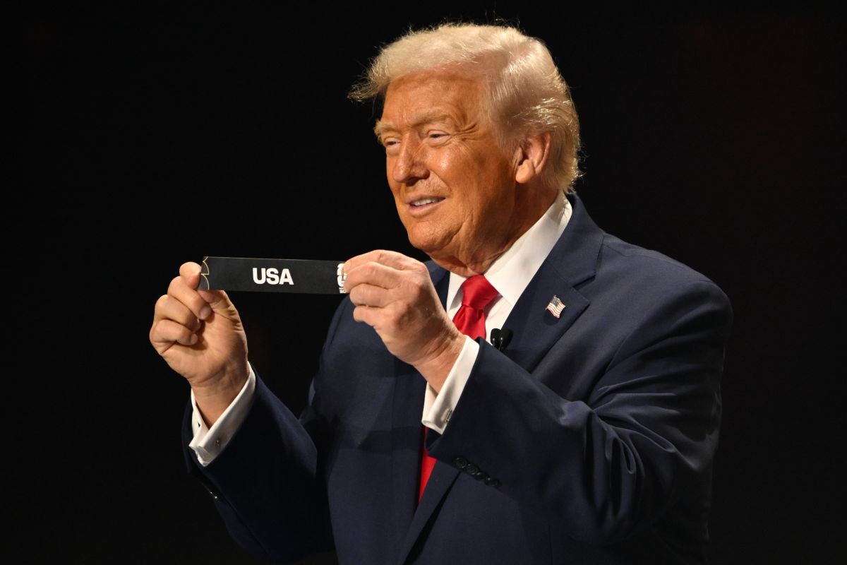 President Donald Trump holds up USA after drawing from a pot of balls during the draw for the 2026 soccer World Cup at the Kennedy Center in Washington, Friday, Dec. 5, 2025. (Mandel Ngan/Pool Photo via AP)