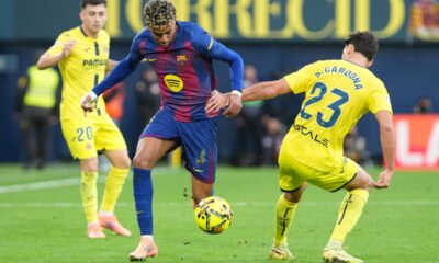 Barcelona's Lamine Yamal, center, vies for the ball with Villarreal's Sergi Cardona during the Spanish La Liga soccer match between Villarreal and Barcelona in Villarreal, Spain, Sunday, Dec. 21, 2025. (AP Photo/Alberto Saiz)