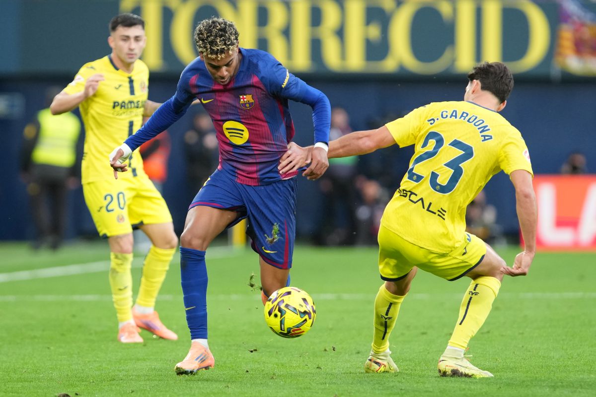 Barcelona's Lamine Yamal, center, vies for the ball with Villarreal's Sergi Cardona during the Spanish La Liga soccer match between Villarreal and Barcelona in Villarreal, Spain, Sunday, Dec. 21, 2025. (AP Photo/Alberto Saiz)