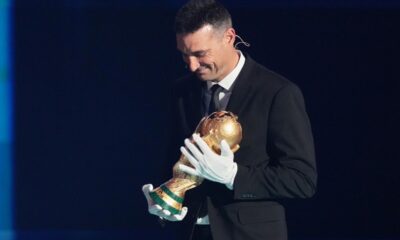Argentina's coach Lionel Scaloni brings the World Cup trophy on stage during the draw for the 2026 soccer World Cup at the Kennedy Center in Washington, Friday, Dec. 5, 2025. (AP Photo/Stephanie Scarbrough, Pool)