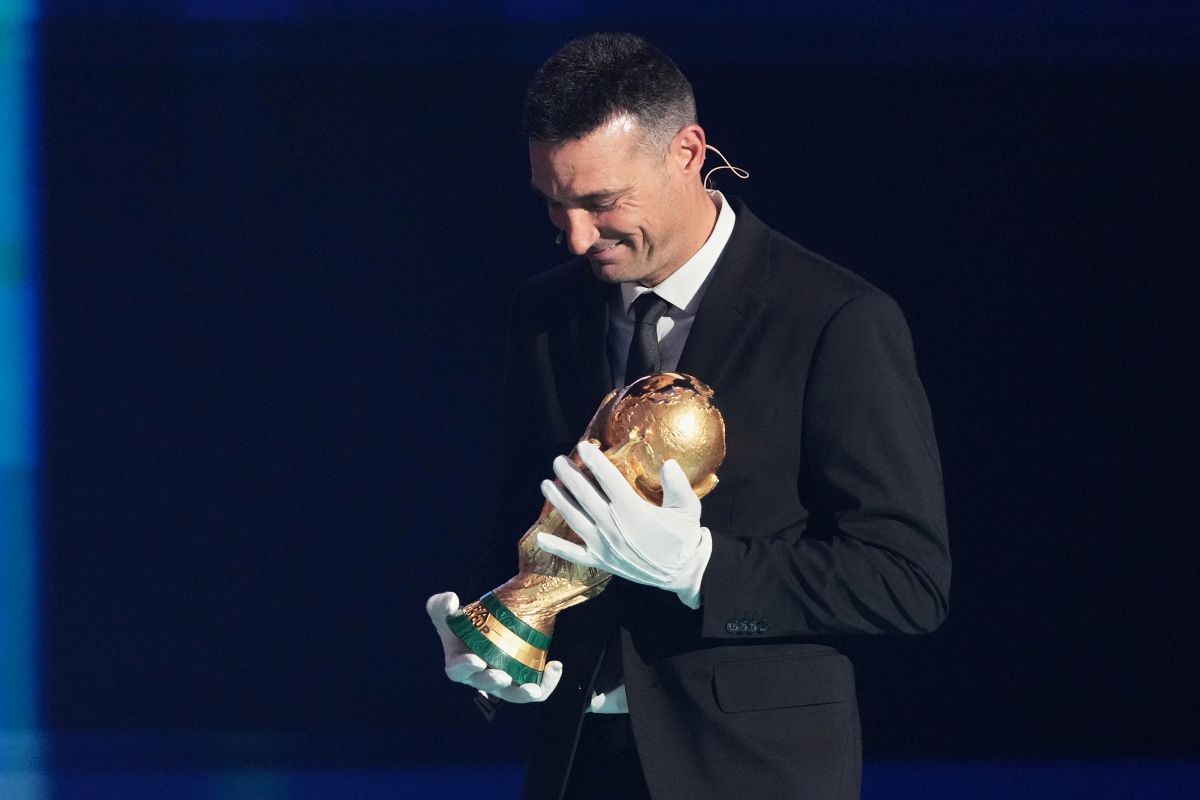 Argentina's coach Lionel Scaloni brings the World Cup trophy on stage during the draw for the 2026 soccer World Cup at the Kennedy Center in Washington, Friday, Dec. 5, 2025. (AP Photo/Stephanie Scarbrough, Pool)