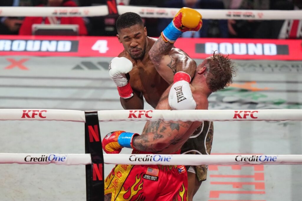 Jake Paul, right, and Anthony Joshua compete in their heavyweight boxing match, Friday, Dec. 19, 2025, in Miami, Fla. (AP Photo/Lynne Sladky)