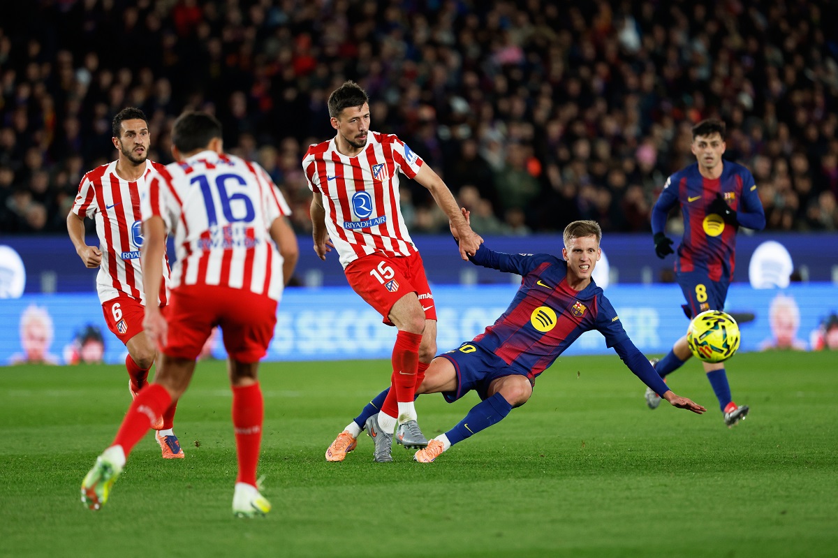 Atletico Madrid's Clement Lenglet fights for the ball against Barcelona's Dani Olmo during a Spanish La Liga soccer match between Barcelona and Atletico de Madrid, in Barcelona, Spain, Tuesday, Dec.2, 2025. (AP Photo/Joan Monfort)