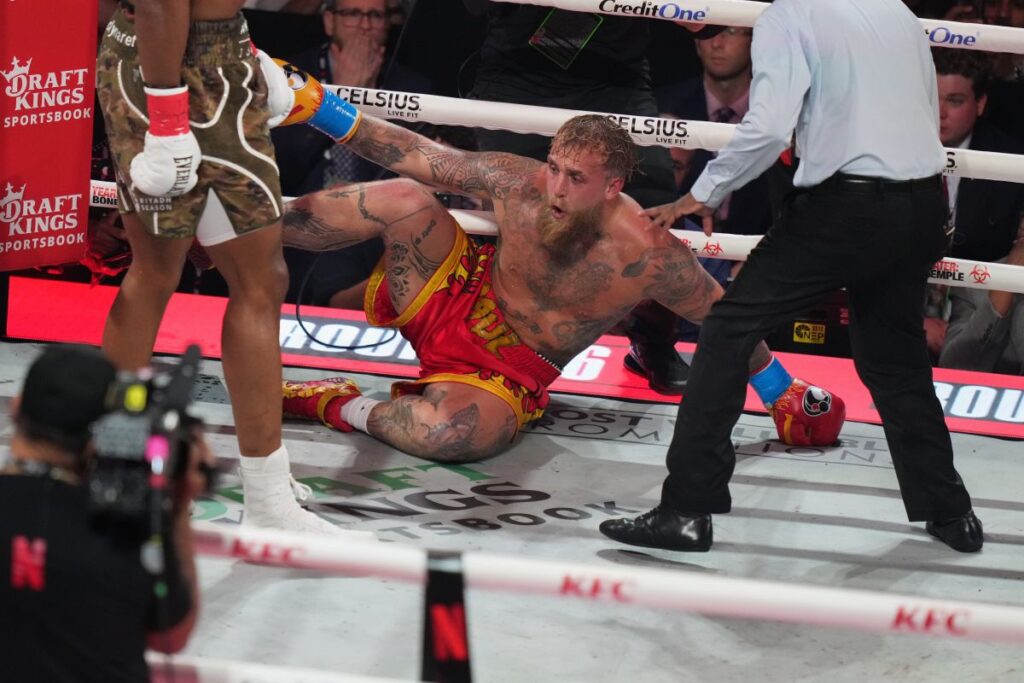 Jake Paul falls on the canvas after being hit by Anthony Joshua during their heavyweight boxing match, Friday, Dec. 19, 2025, in Miami, Fla. (AP Photo/Lynne Sladky)