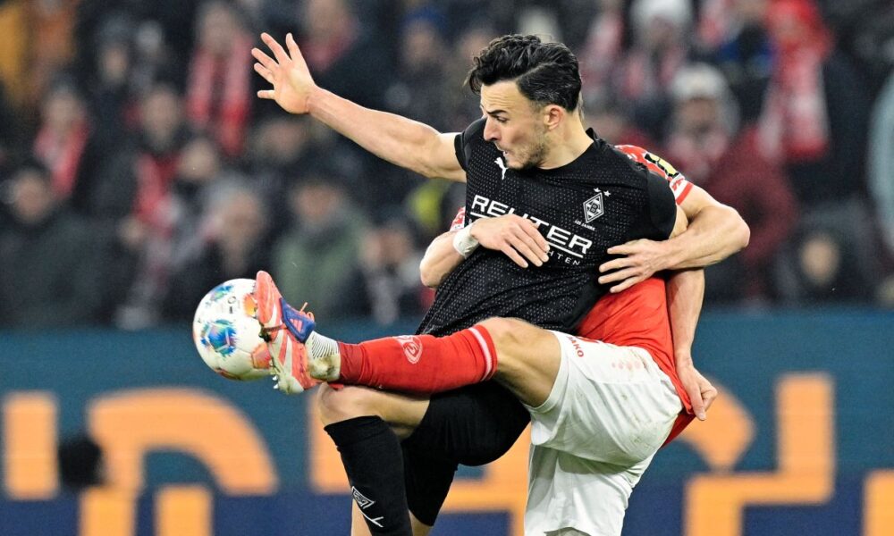 Borussia Mönchengladbach Haris Tabakovic, left, and FSV Mainz 05's Andreas Hanche-Olsen battle for the ball during a Bundesliga soccer match, Friday, Dec. 5, 2025, in Mainz, Germany. (Uwe Anspach/dpa via AP)