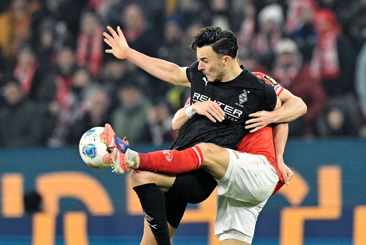 Borussia Mönchengladbach Haris Tabakovic, left, and FSV Mainz 05's Andreas Hanche-Olsen battle for the ball during a Bundesliga soccer match, Friday, Dec. 5, 2025, in Mainz, Germany. (Uwe Anspach/dpa via AP)