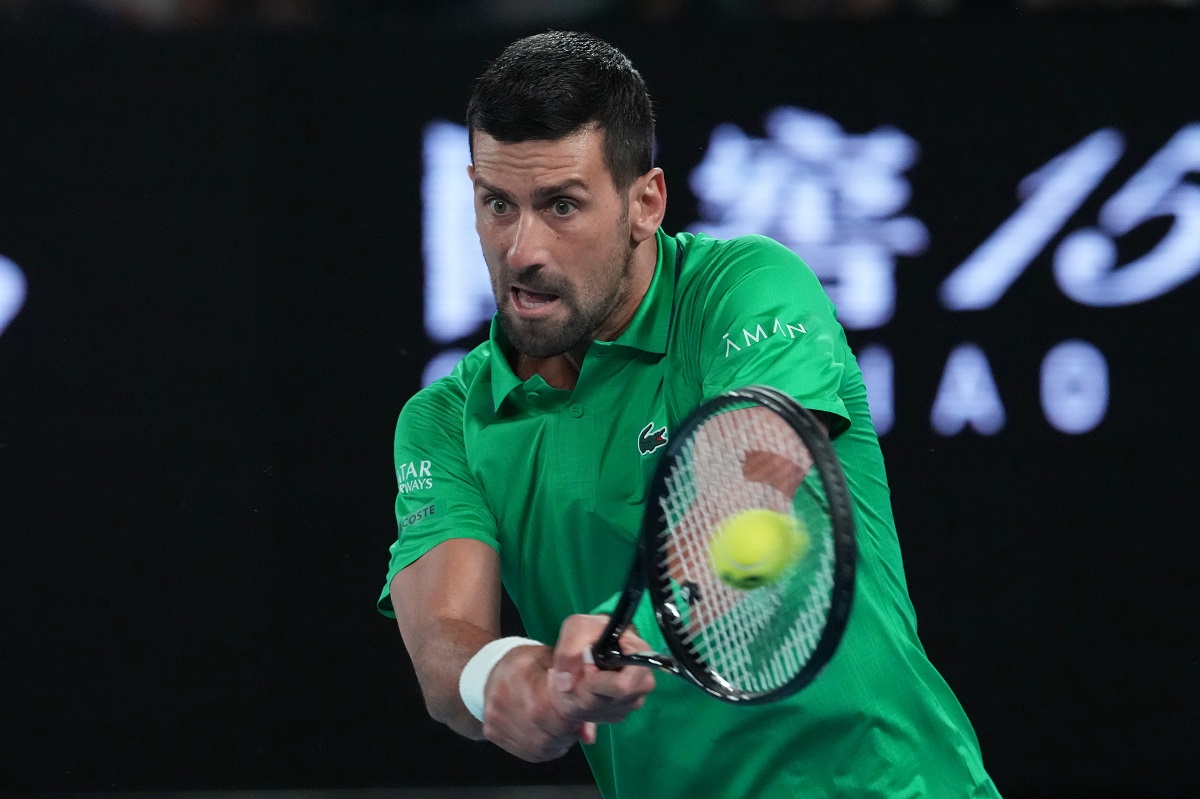 Novak Djokovic of Serbia plays a backhand return to Pedro Martinez of Spain during their first round match at the Australian Open tennis championship in Melbourne, Australia, Monday, Jan. 19, 2026. (AP Photo/Aaron Favila)
