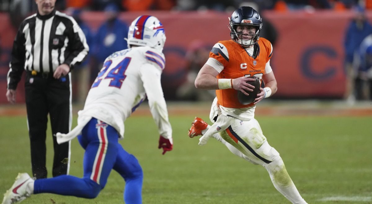 Denver Broncos quarterback Bo Nix, right, runs as Buffalo Bills safety Cole Bishop pursues in overtime of an NFL divisional football game Saturday, Jan. 17, 2026, in Denver. (AP Photo/David Zalubowski)