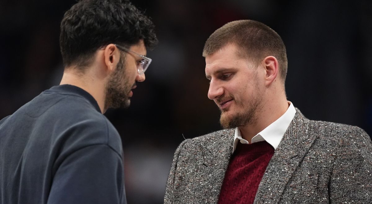 Injured Washington Wizards forward Tristan Vukcevic, left, chats with injured Denver Nuggets center Nikola Jokić before the start of the second half of an NBA basketball game Saturday, Jan. 17, 2026, in Denver. (AP Photo/David Zalubowski)