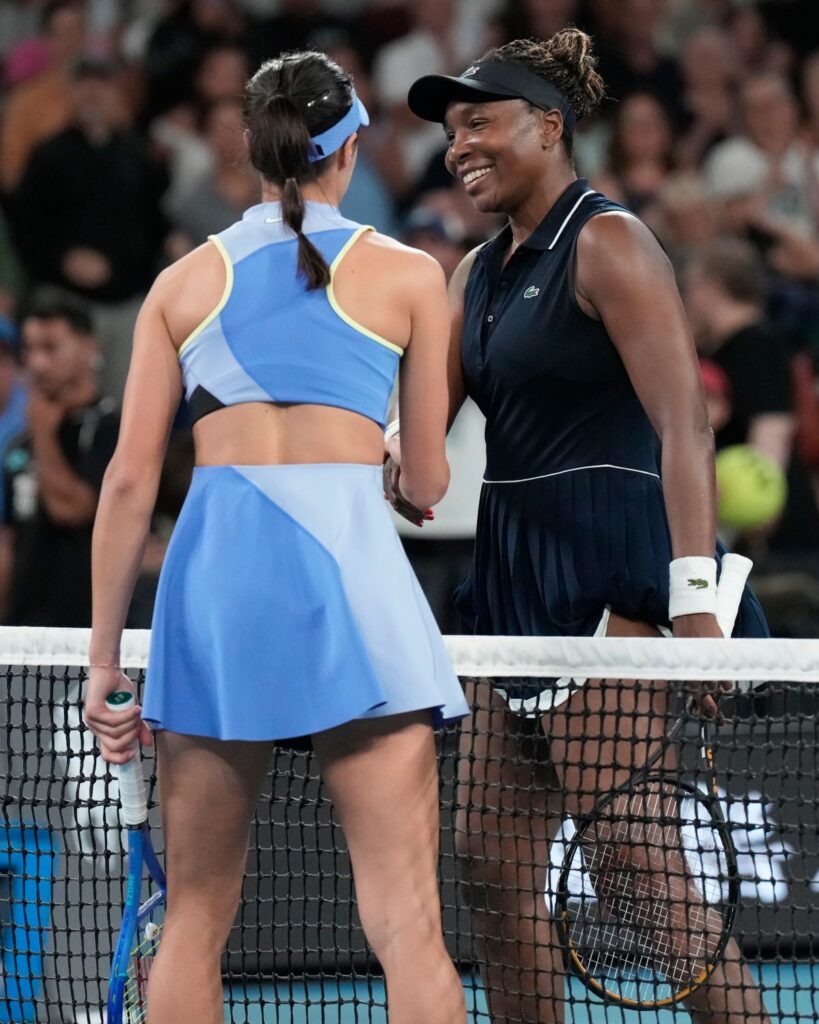 Olga Danilovic, left, of Serbia is congratulated by Venus Williams of the U.S. following their first round match at the Australian Open tennis championship in Melbourne, Australia, Sunday, Jan. 18, 2026. (AP Photo/Aaron Favila)