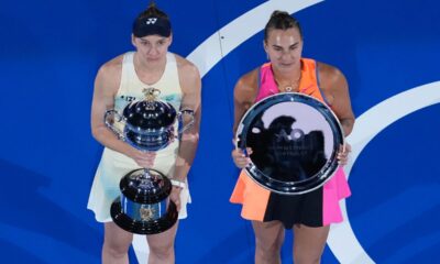 Elena Rybakina of Kazakhstan holds The Daphne Akhurst Memorial Cup, left after defeating Aryna Sabalenka of Belarus at right during the trophy ceremony for the women's singles final at the Australian Open tennis championship in Melbourne, Australia, Saturday, Jan. 31, 2026. (AP Photo/Dar Yasin)