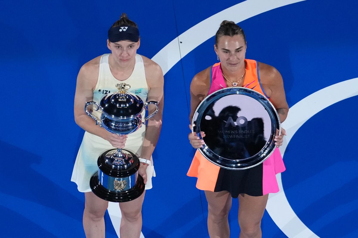 Elena Rybakina of Kazakhstan holds The Daphne Akhurst Memorial Cup, left after defeating Aryna Sabalenka of Belarus at right during the trophy ceremony for the women's singles final at the Australian Open tennis championship in Melbourne, Australia, Saturday, Jan. 31, 2026. (AP Photo/Dar Yasin)
