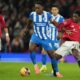 Brighton's Danny Welbeck, left, and Manchester United's Kobbie Mainoo fight for the ball during the FA Cup third round soccer match between Manchester United and Brighton in Manchester, England, Sunday, Jan. 11, 2026. (AP Photo/Jon Super)