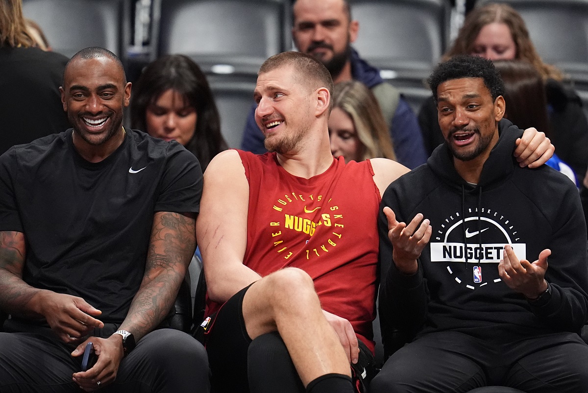 Returning from an injury, Denver Nuggets center Nikola Jokić, center, jokes with player development coaches Darrell Arthur, left, and Cam Griffin, right, before warming up for an NBA basketball game against the Los Angeles Clippers, Friday, Jan. 30, 2026, in Denver. (AP Photo/David Zalubowski)