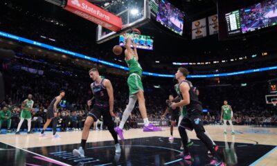 Boston Celtics guard Jordan Walsh (27) dunks over Miami Heat forward Nikola Jovic (5) and guard Pelle Larsson during the first half of an NBA basketball game, Thursday, Jan. 15, 2026, in Miami. (AP Photo/Rebecca Blackwell)