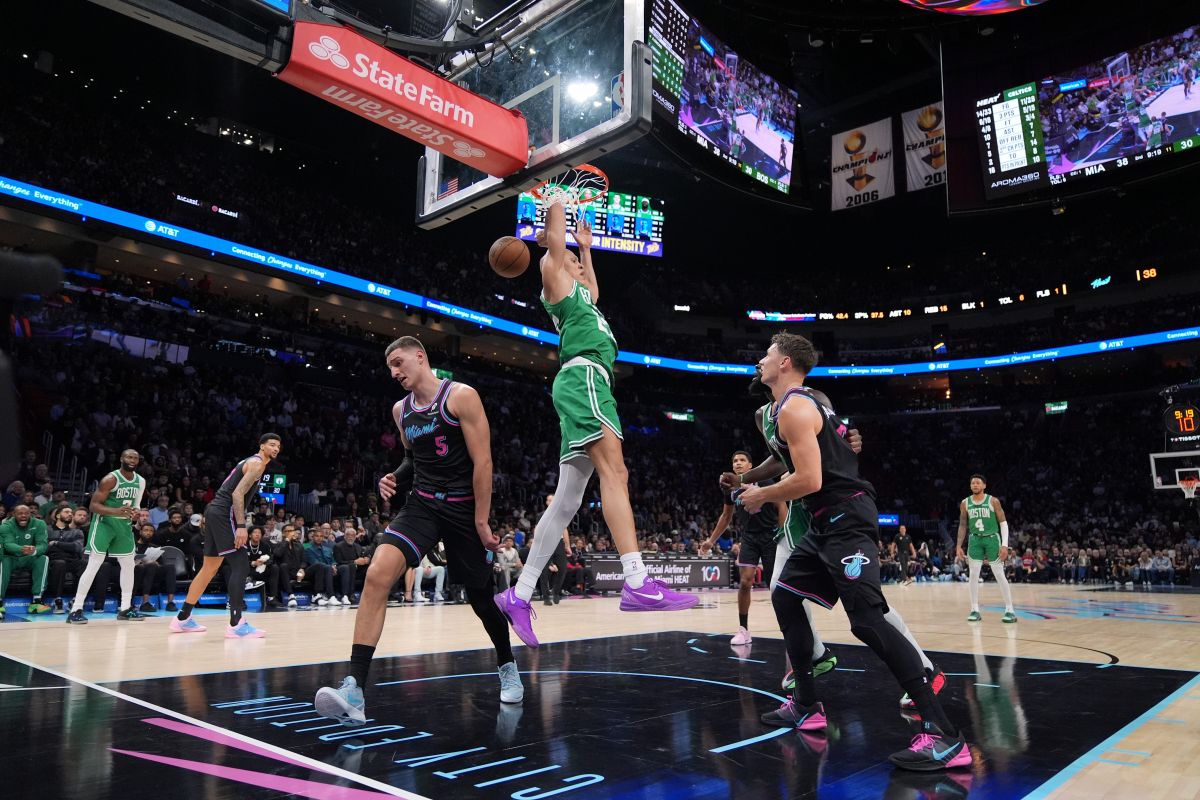 Boston Celtics guard Jordan Walsh (27) dunks over Miami Heat forward Nikola Jovic (5) and guard Pelle Larsson during the first half of an NBA basketball game, Thursday, Jan. 15, 2026, in Miami. (AP Photo/Rebecca Blackwell)