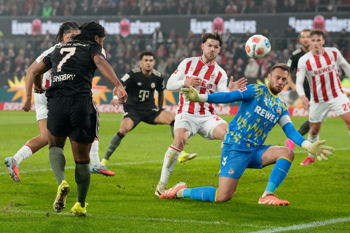 Bayern's Serge Gnabry, left, scores his side's opening goal during the German Bundesliga soccer match between 1.FC Koeln and FC Bayern Munich in Cologne, Germany, Wednesday, Jan. 14, 2026. (AP Photo/Martin Meissner)