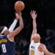 Denver Nuggets guard Peyton Watson (8) shoots over Boston Celtics guard Derrick White (9) during the second half of an NBA basketball game, Wednesday, Jan. 7, 2026, in Boston. (AP Photo/Charles Krupa)