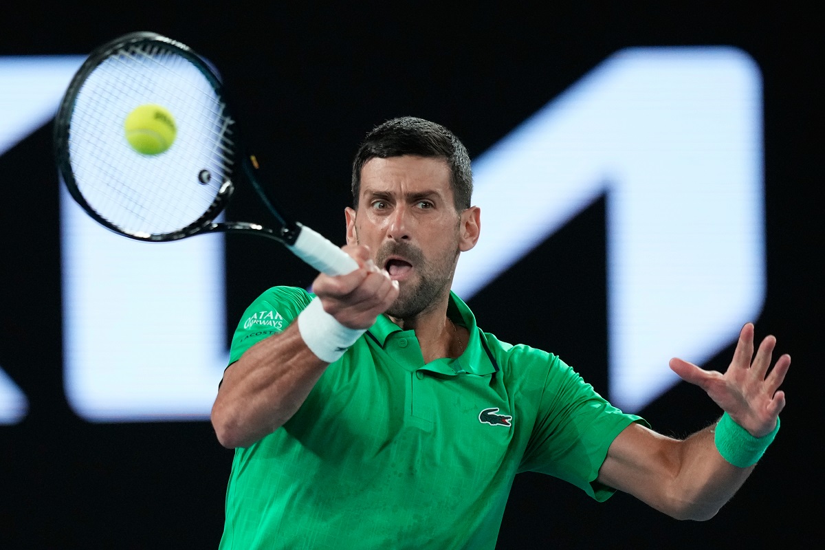 Novak Djokovic of Serbia plays a forehand return to Pedro Martinez of Spain during their first round match at the Australian Open tennis championship in Melbourne, Australia, Monday, Jan. 19, 2026. (AP Photo/Aaron Favila)