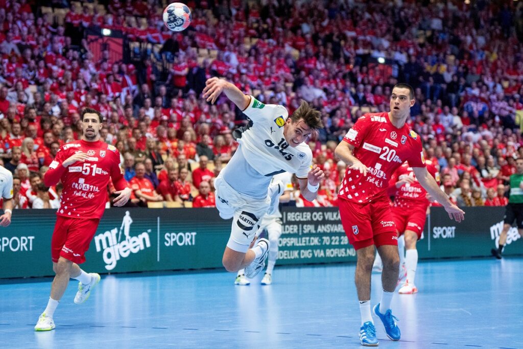 Germany's Julian Köster in action with Croatia's Ivan Martinovic and Mateo Maras, right, during the men's semifinal handball match between Germany and Croatia in Herning, Denmark, Friday Jan. 30, 2026. (Bo Amstrup/Ritzau Scanpix via AP)