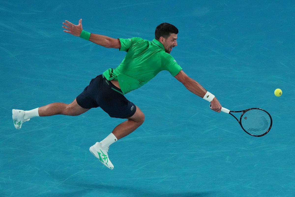 Novak Djokovic of Serbia plays a backhand return to Pedro Martinez of Spain during their first round match at the Australian Open tennis championship in Melbourne, Australia, Monday, Jan. 19, 2026. (AP Photo/Aaron Favila)