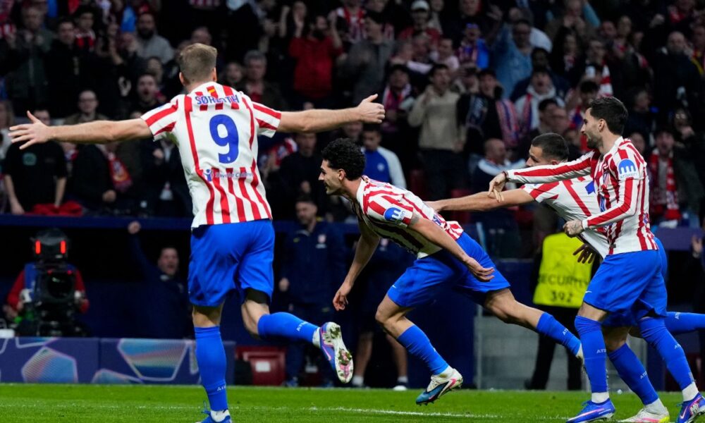 Atletico Madrid's Johnny Cardoso, center, celebrates after scoring his side's second goal during the Champions League play-off second leg soccer match between Atletico Madrid and Club Brugge, in Madrid, Spain, Tuesday, Feb. 24, 2026. (AP Photo/Manu Fernandez)