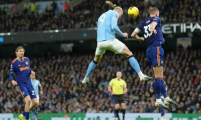 Manchester City's Erling Haaland, left, and Newcastle's Dan Burn jump for the ball during the English Premier League soccer match between Manchetser City nad Newcastle in Manchester, England, Saturday, Feb. 21, 2026. (AP Photo/Jon Super)