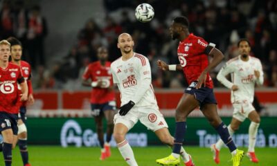 Lille's Mbemba Manguluc Chancel, centre right, challenges for the ball during the French League One soccer match between Lille and Brest in Villeneuve-d'Ascq, outside Lille, France, Saturday, Feb. 14, 2026. (AP Photo/Jean-Francois Badias)