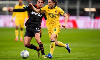 Como's Nico Paz, left, fights for the ball with AC Milan's Luka Modric during the Serie A soccer match in Milan, Italy, Wednesday, Feb., 18 2026. (Fabio Ferrari/LaPresse via AP)