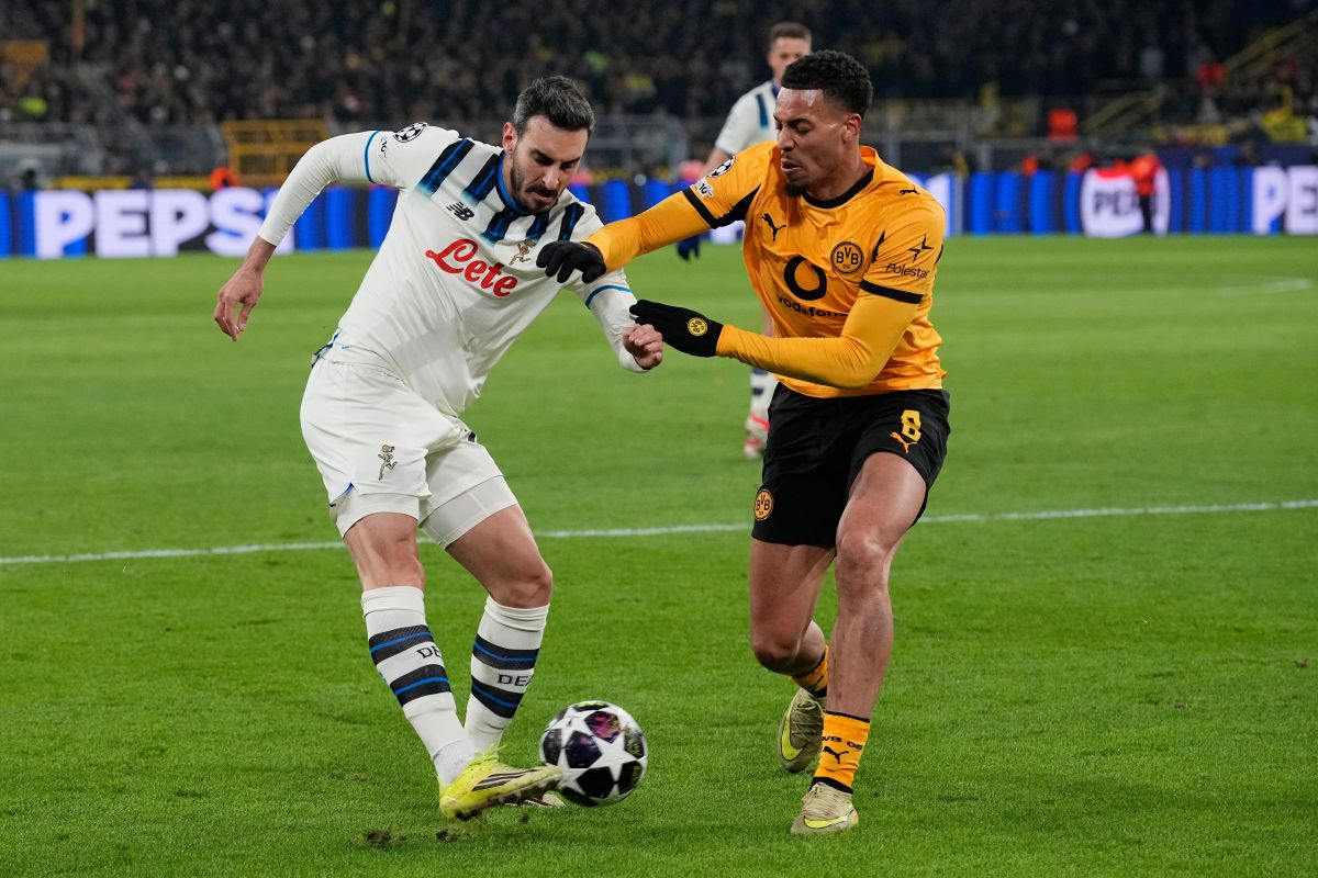 Atalanta's Davide Zappacosta sends a cros by Dortmund's Felix Nmecha during the Champions League knockout playoff first leg soccer match between Borussia Dortmund and Atalanta in Dortmund, Germany, Tuesday, Feb. 17, 2026. (AP Photo/Martin Meissner)