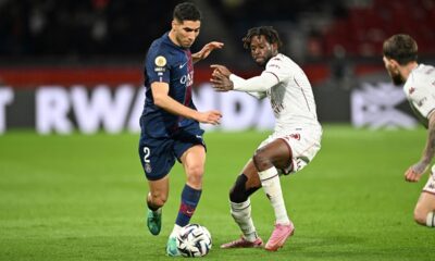 PSG's Achraf Hakimi, left, and Metz's Boubacar Traore challenge for the ball during the French League One soccer match between Paris Saint-Germain and Metz in Paris, France, Saturday, Feb. 21, 2026. (AP Photo/Emma Da Silva)