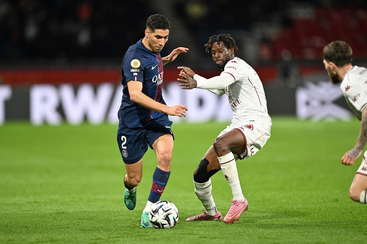 PSG's Achraf Hakimi, left, and Metz's Boubacar Traore challenge for the ball during the French League One soccer match between Paris Saint-Germain and Metz in Paris, France, Saturday, Feb. 21, 2026. (AP Photo/Emma Da Silva)